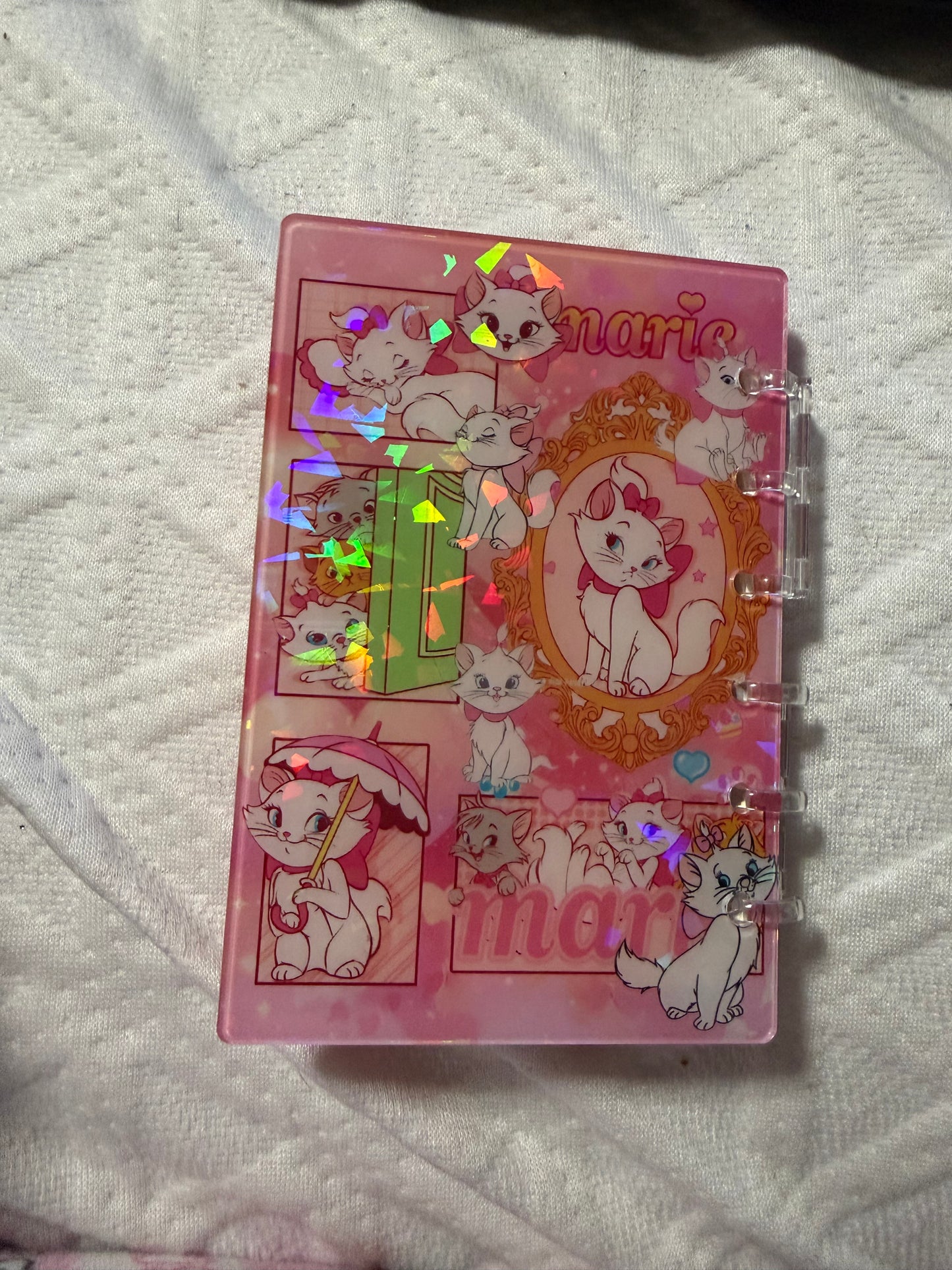 FLUFFY WHITE CAT BED WITH PINK CAT COLOR WITH NOTEBOOK STANDING UP ON BED
