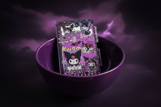 NOTEBOOK IN THE MIDDLE OF PURPLE BOWE WITH CLOUDY BLACK AND PURPLE BACKROUND